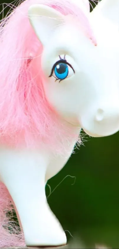 Cute toy horse with pink mane and vivid eyes on a green background.