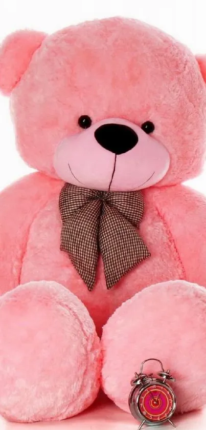 Cute pink teddy bear with brown bowtie and small clock.