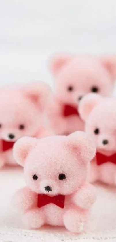 Fluffy pink teddy bears with red bows on white background.