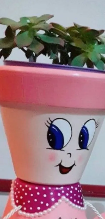 Smiling pink plant pot with green leaves.