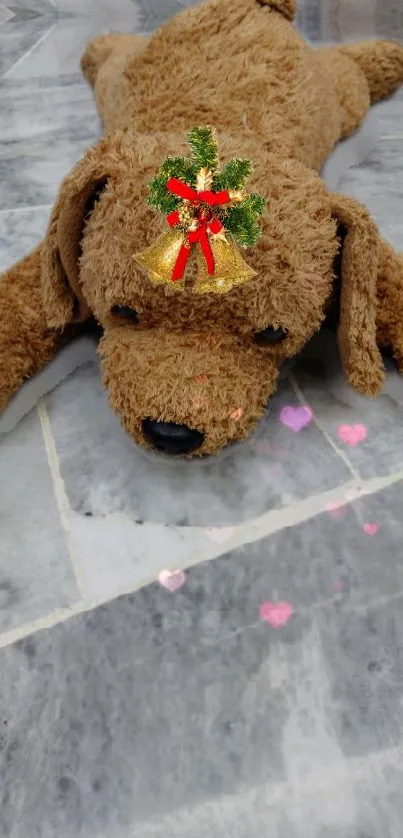 Cute plush dog with a festive bell on a grey marble background.