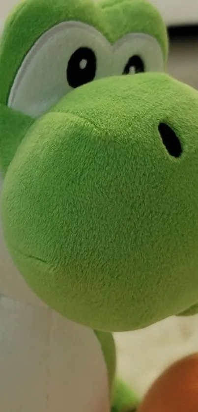 Green plush dinosaur toy with large eyes on a soft background.