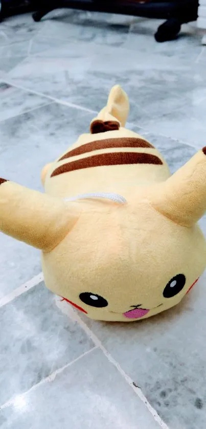 Yellow and brown plush toy on a marble floor background.