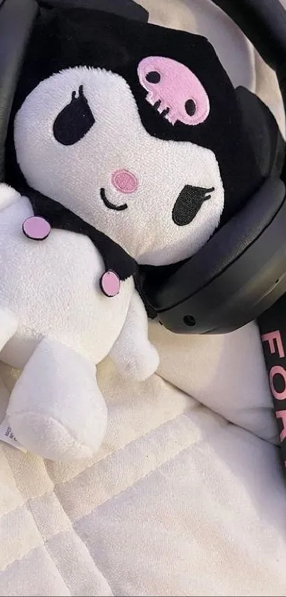 Plush toy with headphones and book on quilt.