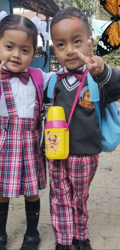 Two smiling school kids posing with peace signs and a butterfly in the background.