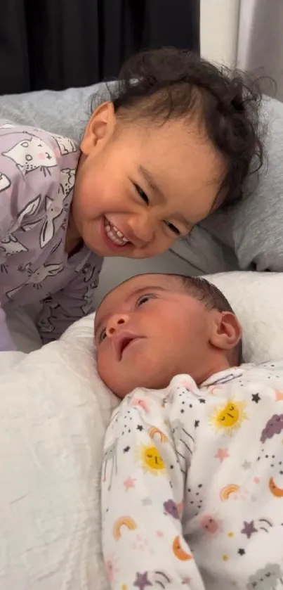 Smiling siblings enjoying bedtime cuddles.