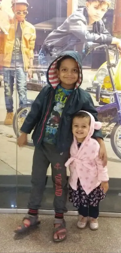 Two siblings smiling in a shopping mall setting.