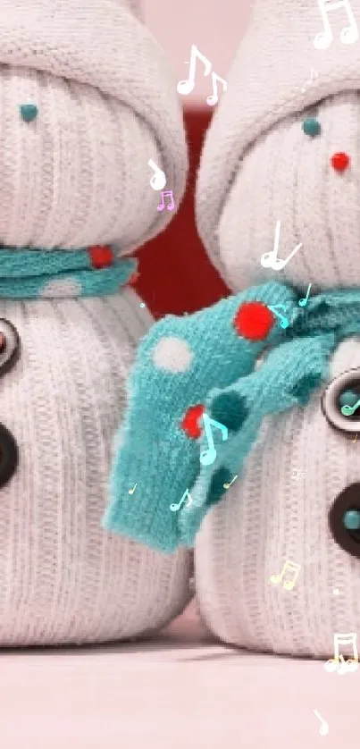 Two adorable sock snowmen with scarves on a mobile wallpaper.