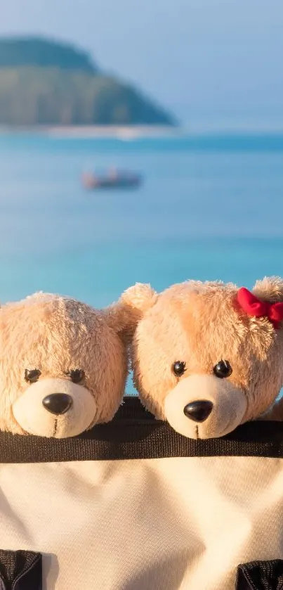 Two teddy bears on a beach with a blue ocean backdrop.