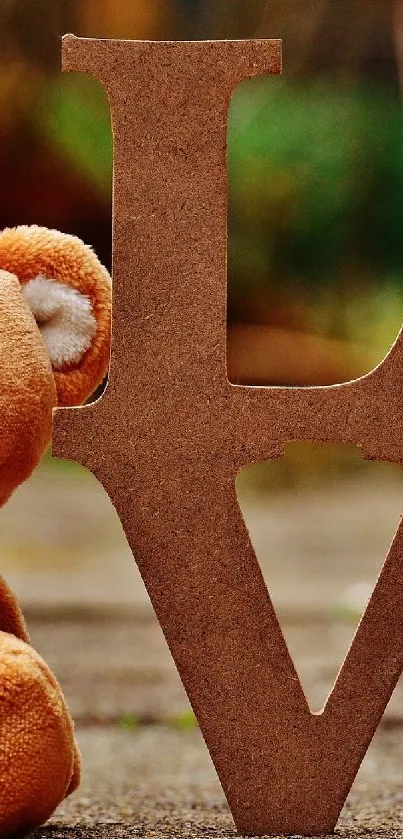 Teddy bear with 'LOVE' cutout on natural background.