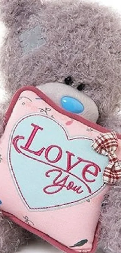 Cute teddy bear holding a love heart pillow.