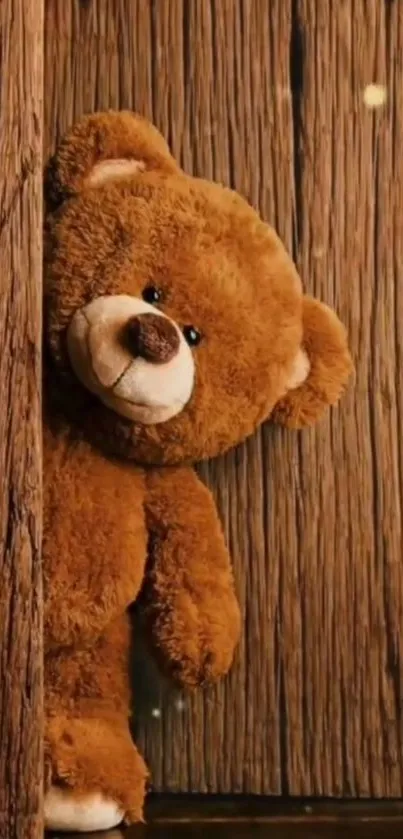 Cute teddy bear peeking from a rustic wooden background in cozy brown tones.