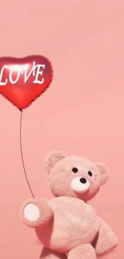 Teddy bear holding a heart-shaped balloon on a pink background.