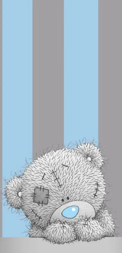 Cute gray teddy bear on blue and gray striped background.