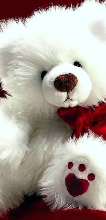 Adorable white teddy bear with red bow on deep red background.