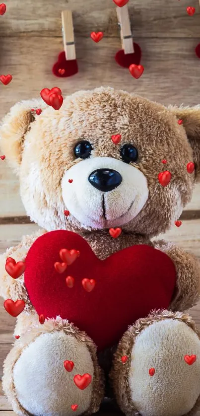 A cuddly teddy bear holding a red heart on a wooden background.