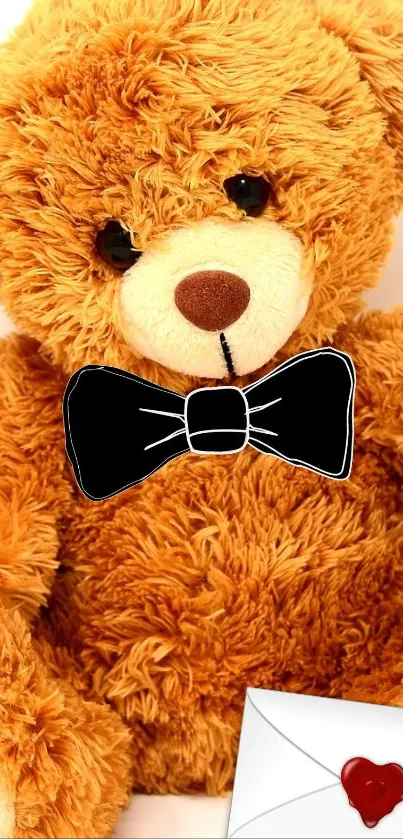 Cute teddy bear with a black bow tie and red heart envelope.