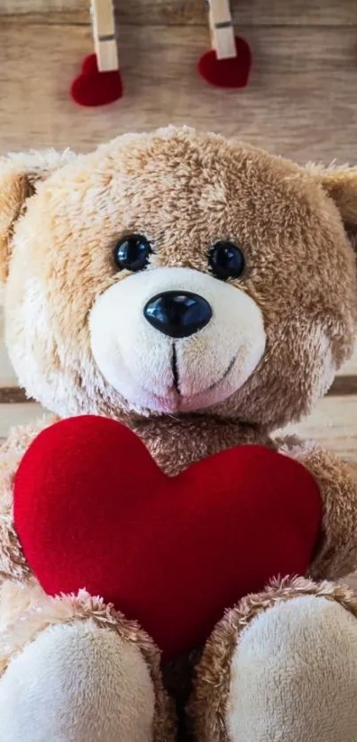 Cute teddy bear with red heart on wooden backdrop.