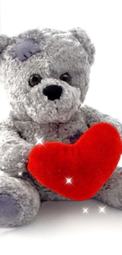 Gray teddy bear with red heart sparkles.