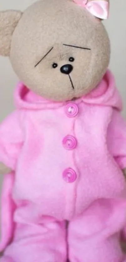 Teddy bear wearing pink pajamas with a cute pink bow.