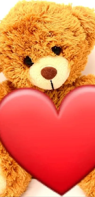 Cute teddy bear holding a red heart symbol.