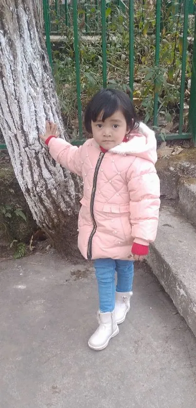 Child in pink winter coat outdoors, on steps.