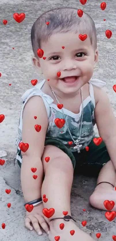 Adorable toddler smiling while sitting on concrete.