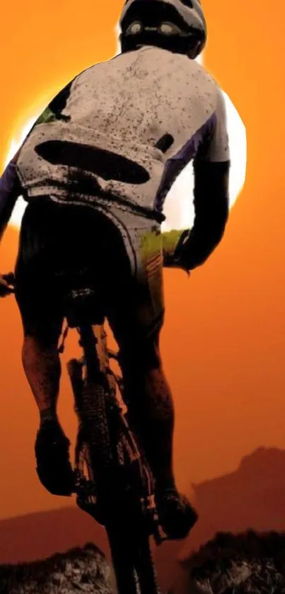 Silhouette of a cyclist at sunset with an orange sky backdrop.