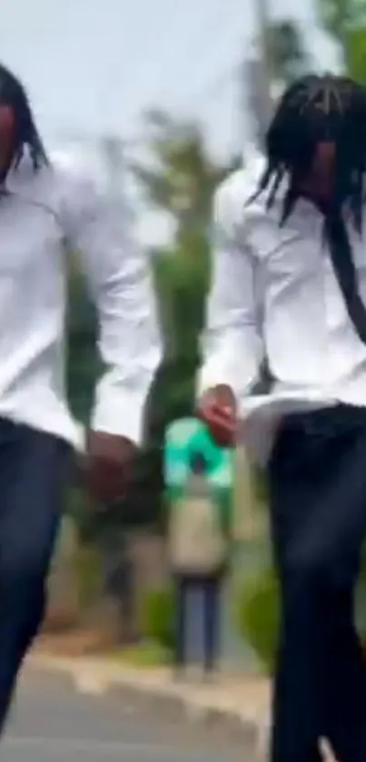 Two people dancing energetically on the street in stylish attire.
