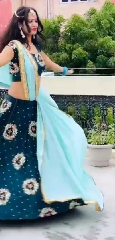 Woman elegantly dancing in a turquoise traditional dress.