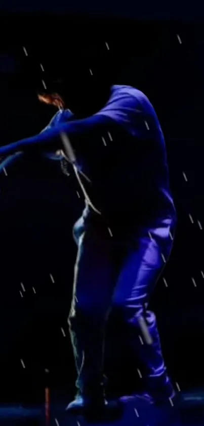 Dancer performing under blue neon lights at night.