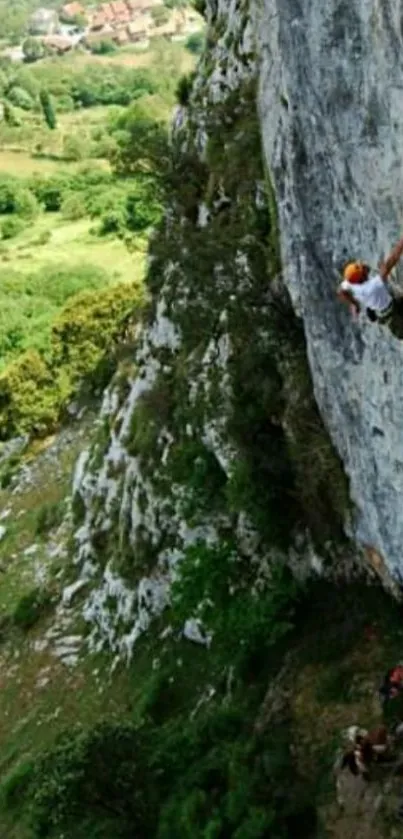 Climber on a steep cliff with green landscape background.