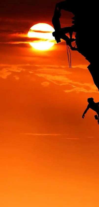 Sunset rock climbing silhouette against an orange sky.