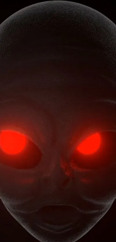 Alien face with glowing red eyes on a dark background wallpaper.