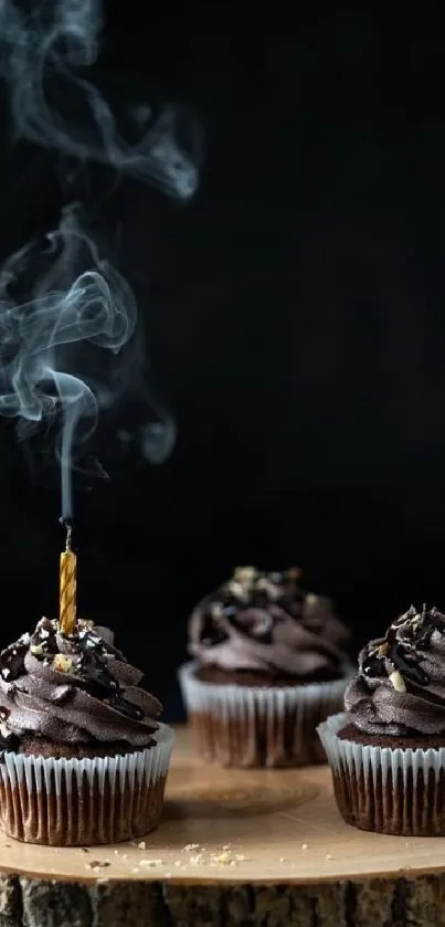 Dark chocolate cupcakes with a smoky candle effect on a wooden board.