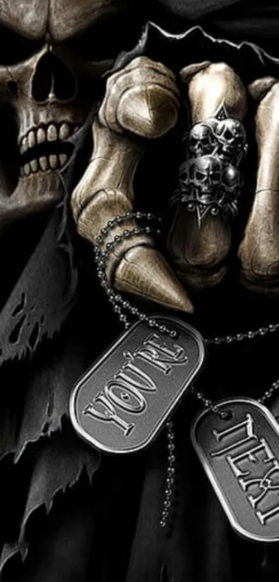 Gothic skull hand holding dog tags in black cloak.