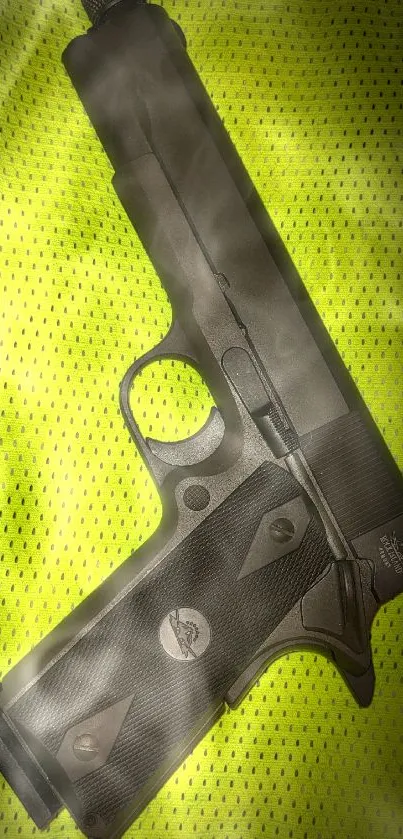 Dark handgun on neon green mesh background wallpaper.