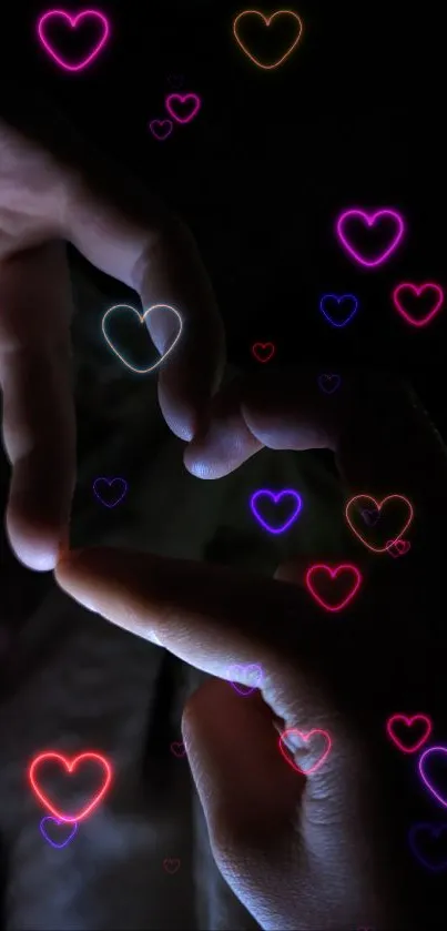 Hands form a glowing heart in darkness.