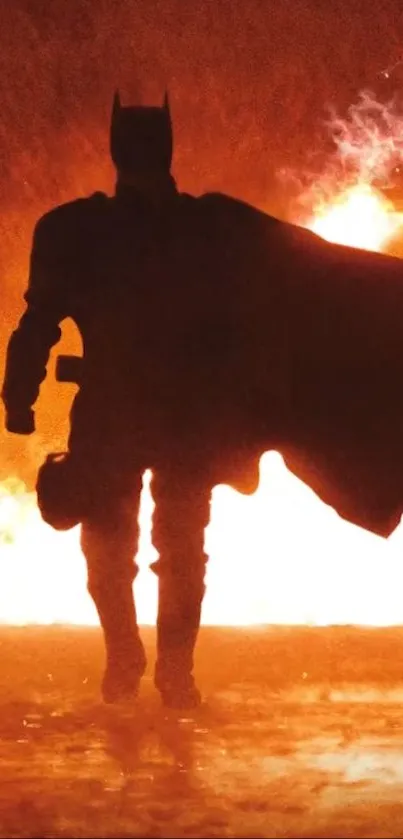 Silhouette of a hero with cape in front of fire.