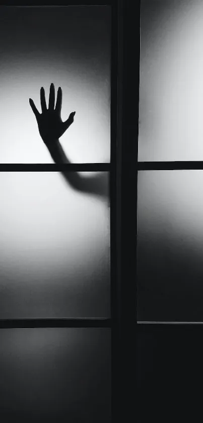 Silhouette of a hand on a frosted glass panel.