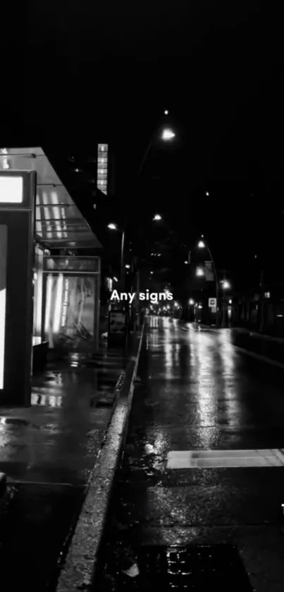 Black and white urban street at night with reflections.