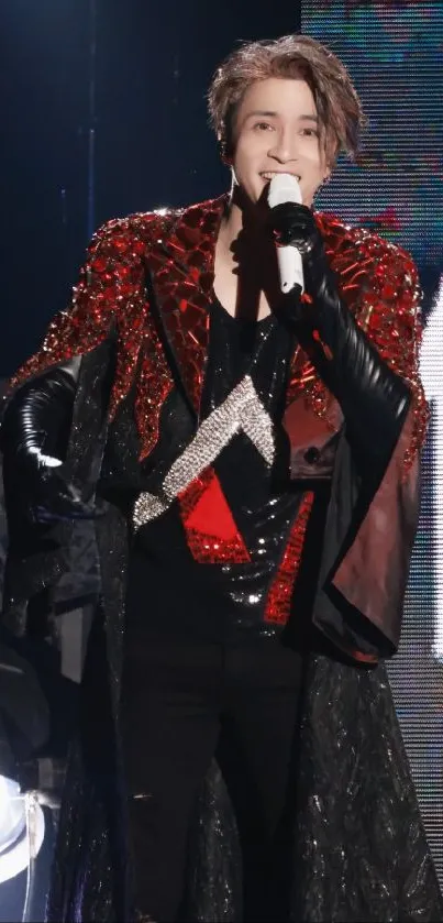 Performer in sparkling red and black outfit on stage.