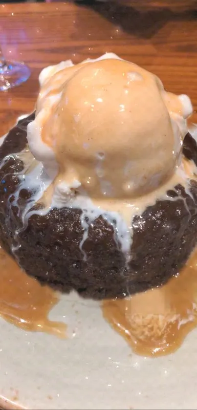 Chocolate cake with ice cream and caramel sauce on top on a plate.