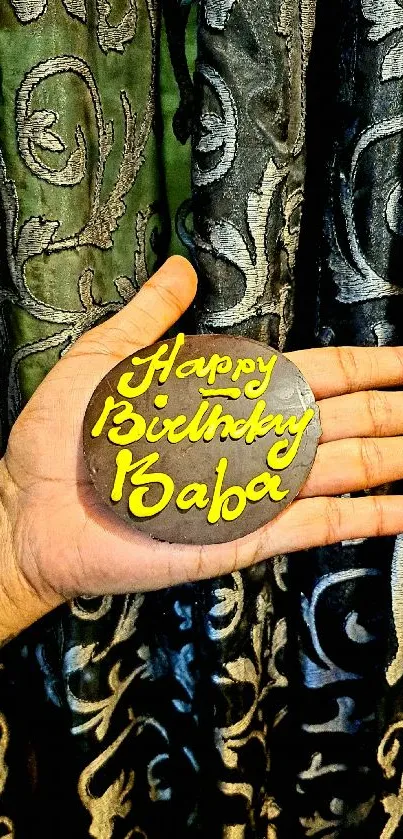 Hand holding a decorative birthday message with unique design.