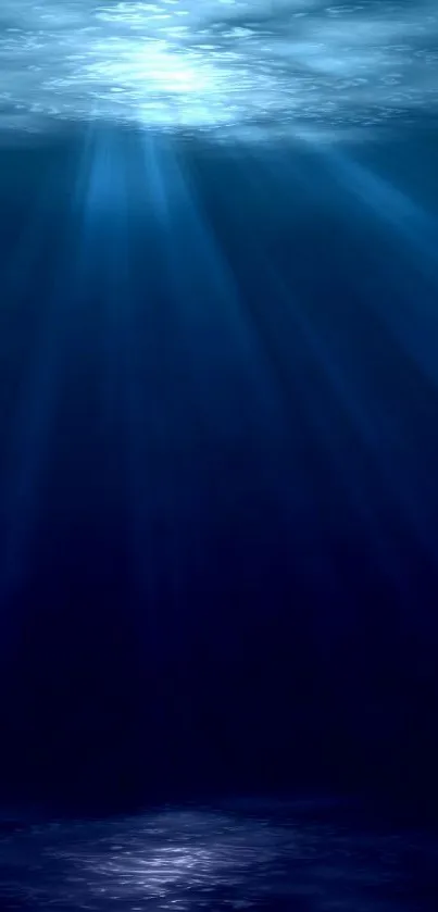 Deep ocean wallpaper with blue hues and sun rays penetrating water.