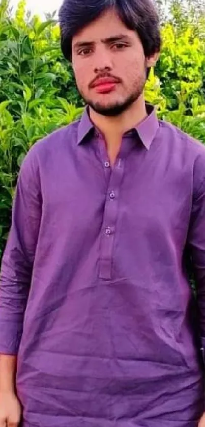 Person in deep purple attire with green foliage background.