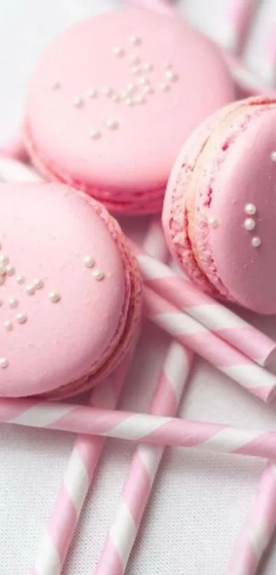 Pink macarons with white pearls on striped straws wallpaper.