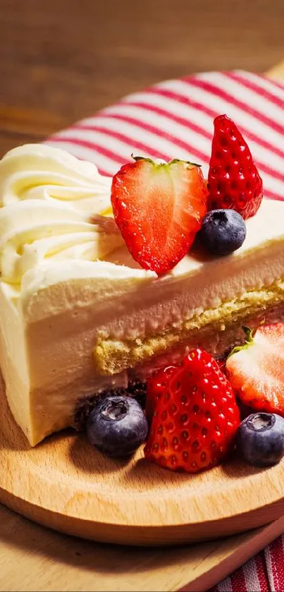 A slice of cake with strawberries and blueberries on a wooden board.