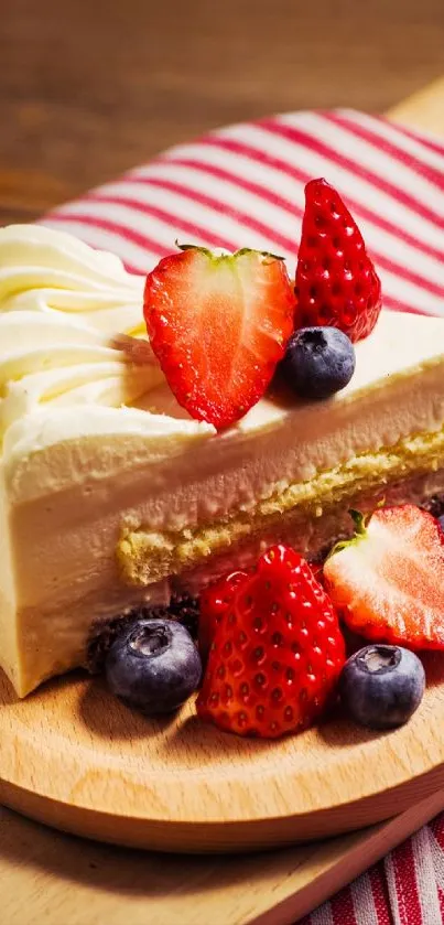 Cake with strawberries and blueberries on a wooden plate.