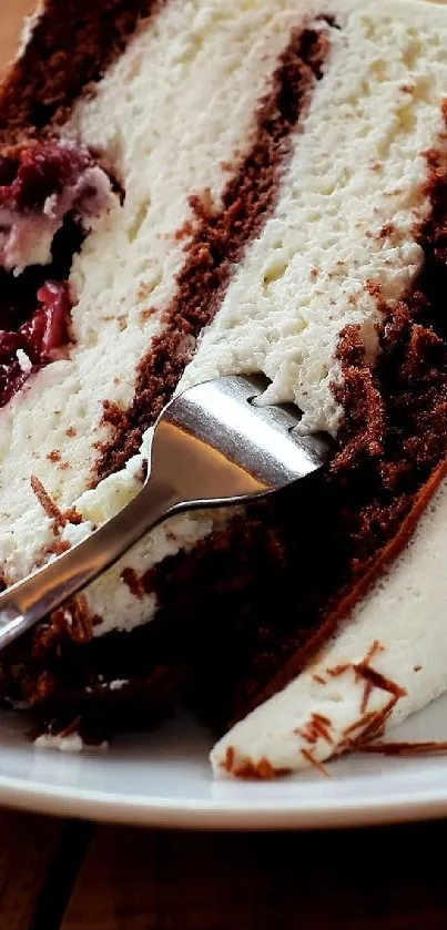 Chocolate and cream cake slice on a white plate with wooden table background.